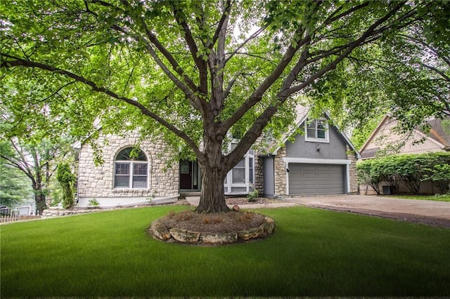 4008 NW 75th St, Kansas City, MO 64151 - view of property hidden behind natural elements featuring stone siding, driveway, a front yard, an attached garage, and stucco siding