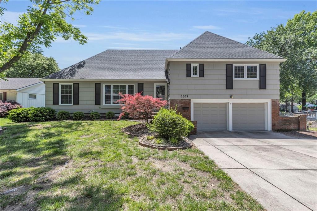 6609 W 100th St, Overland Park, KS 66212 - tri-level home featuring a garage, roof with shingles, concrete driveway, and a front yard
