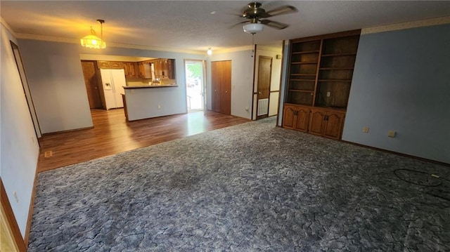 2704 S Taylor St, Pittsburg, KS 66762 - unfurnished living room with crown molding, a ceiling fan, light colored carpet, built in shelves, and light wood-style flooring