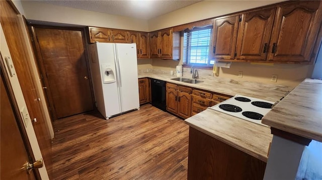 2704 S Taylor St, Pittsburg, KS 66762 - kitchen featuring white appliances, wood finished floors, light countertops, brown cabinets, and a textured ceiling