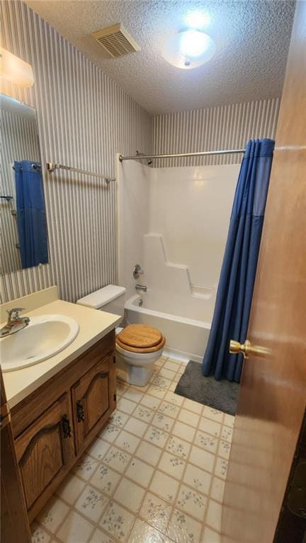 2704 S Taylor St, Pittsburg, KS 66762 - bathroom with wallpapered walls, tile patterned floors, vanity, shower / bath combo with shower curtain, and a textured ceiling