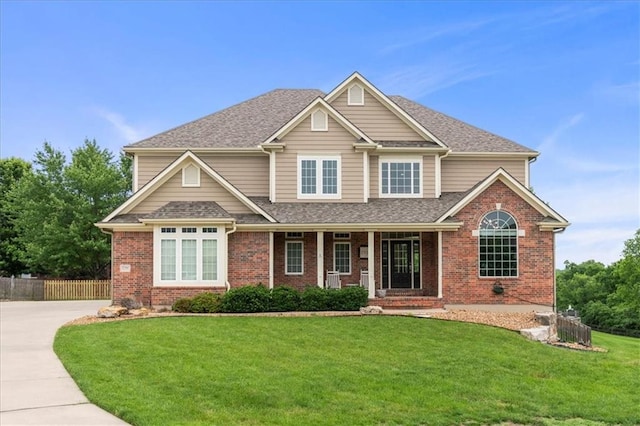 2704 SW Gray Ln, Lees Summit, MO 64081 - view of front of home featuring brick siding, covered porch, roof with shingles, and driveway