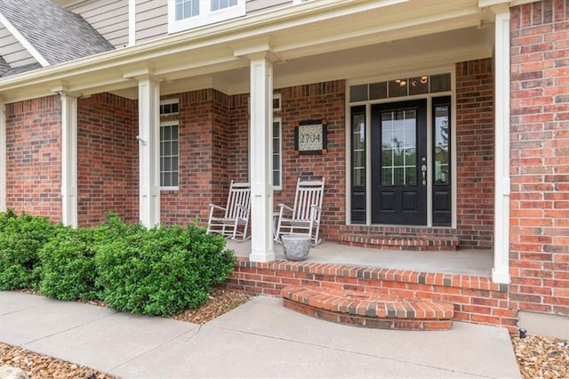 2704 SW Gray Ln, Lees Summit, MO 64081 - entrance to property featuring a porch, brick siding, and a shingled roof