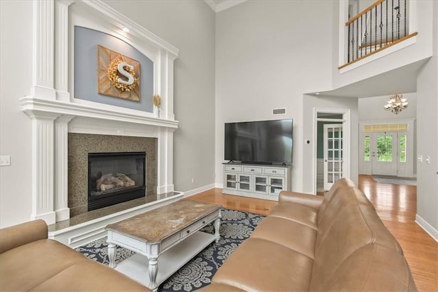 2704 SW Gray Ln, Lees Summit, MO 64081 - living room with wood finished floors, baseboards, a fireplace, a towering ceiling, and a chandelier