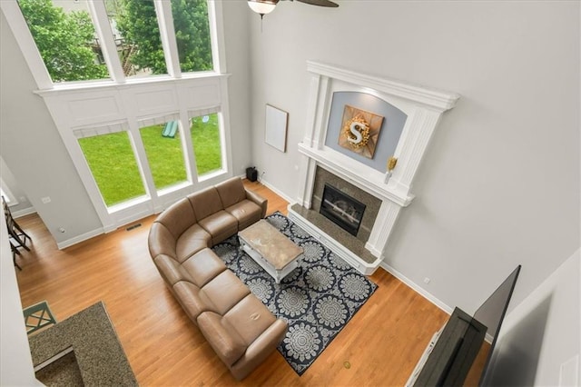 2704 SW Gray Ln, Lees Summit, MO 64081 - living area featuring a high end fireplace, ceiling fan, wood finished floors, and baseboards
