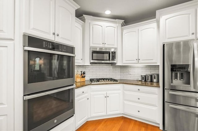 2704 SW Gray Ln, Lees Summit, MO 64081 - kitchen featuring stainless steel appliances, dark stone countertops, white cabinetry, and recessed lighting