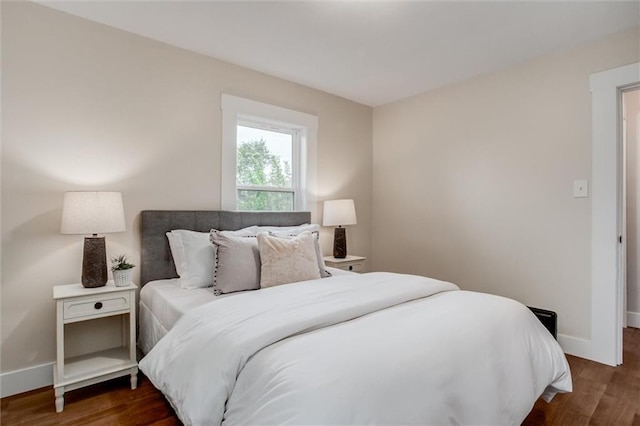 bedroom with baseboards and wood finished floors
