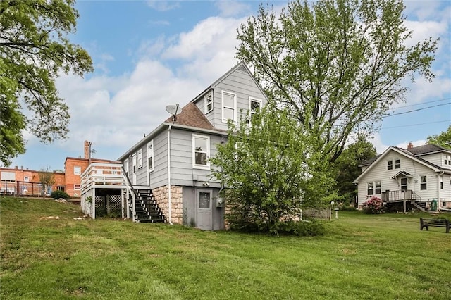 rear view of house featuring stairs, a deck, and a yard