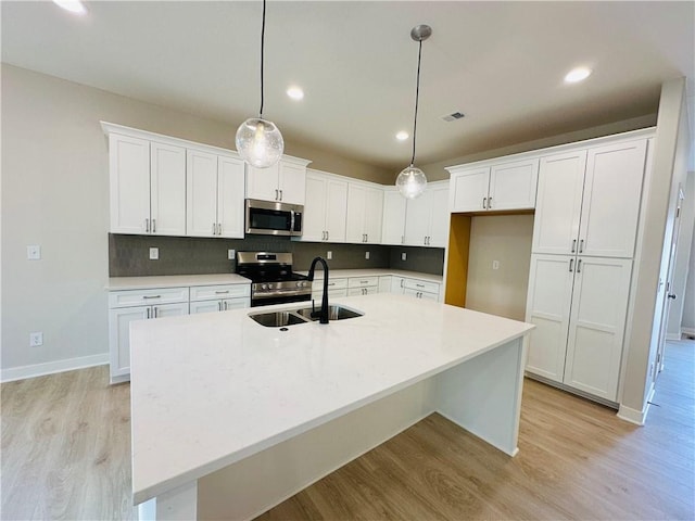 kitchen with visible vents, a sink, light wood-style floors, stainless steel appliances, and white cabinetry