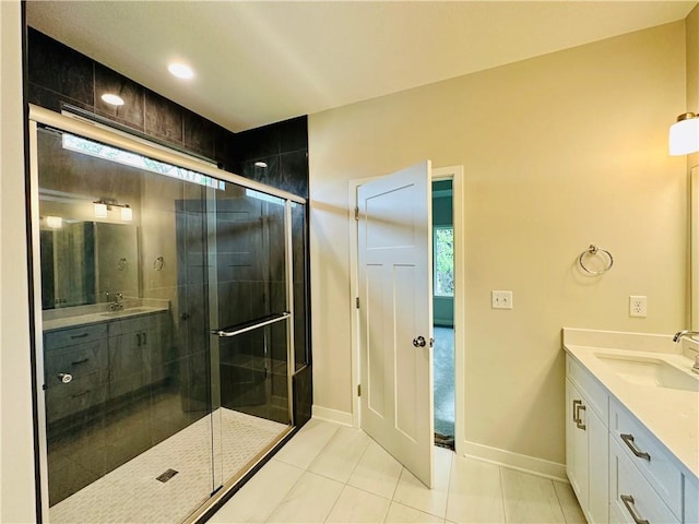 full bathroom featuring tile patterned flooring, baseboards, a shower stall, and vanity