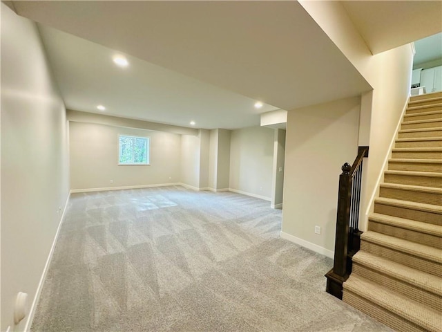 below grade area with recessed lighting, baseboards, stairs, and light colored carpet