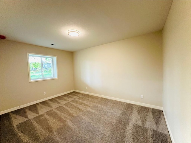 unfurnished room with carpet floors, baseboards, and visible vents