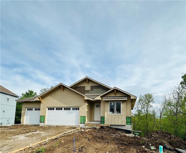 craftsman-style house featuring board and batten siding, an attached garage, and dirt driveway