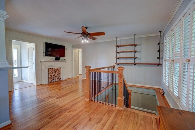 unfurnished living room with crown molding, baseboards, a wealth of natural light, and wood finished floors