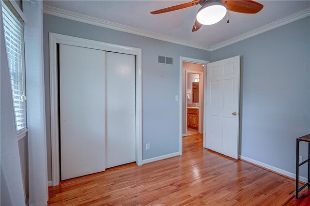 unfurnished bedroom with light wood-style floors, baseboards, ornamental molding, and visible vents