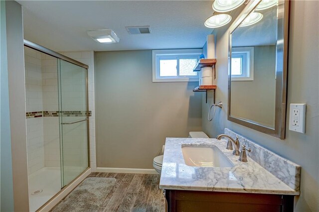 full bath with visible vents, a stall shower, wood finished floors, vanity, and toilet