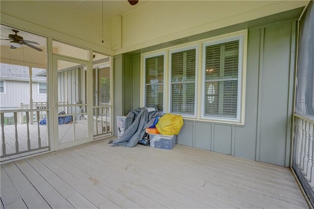 unfurnished sunroom with ceiling fan