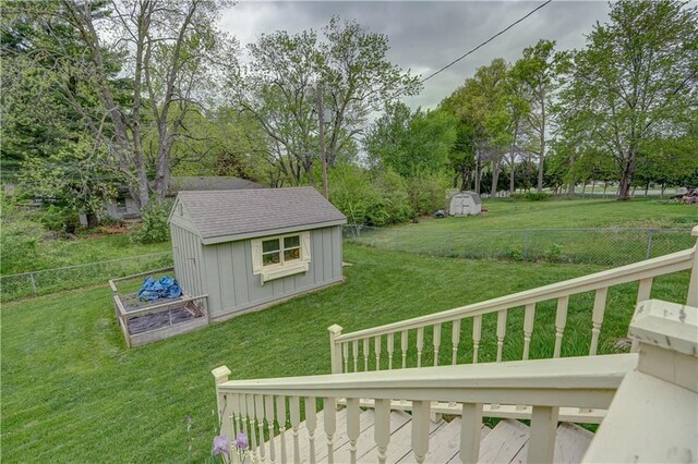 view of yard with a fenced backyard, a storage unit, and an outdoor structure