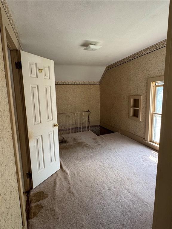 420 S Lincoln Ave, Chanute, KS 66720 - interior space featuring carpet flooring, a textured ceiling, and wallpapered walls
