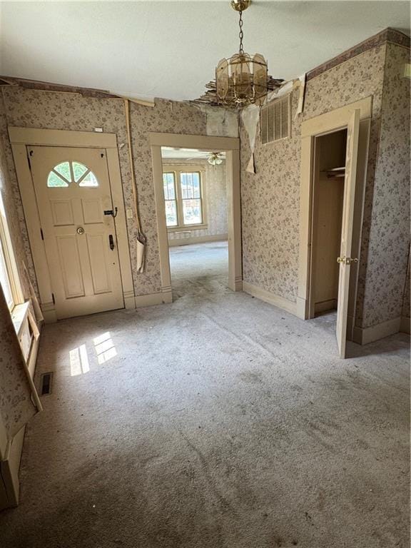 420 S Lincoln Ave, Chanute, KS 66720 - foyer entrance with an inviting chandelier, light carpet, wallpapered walls, baseboards, and visible vents