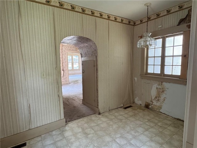 420 S Lincoln Ave, Chanute, KS 66720 - unfurnished dining area with visible vents, arched walkways, a chandelier, and wallpapered walls