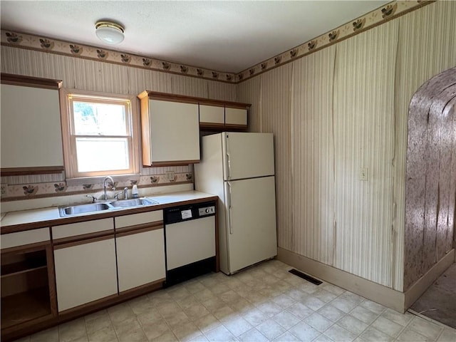 420 S Lincoln Ave, Chanute, KS 66720 - kitchen featuring a sink, white appliances, light countertops, wallpapered walls, and visible vents
