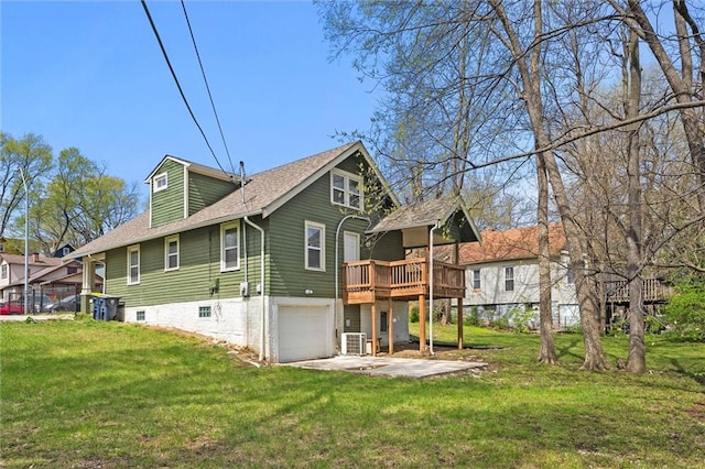 4331 Virginia Ave, Kansas City, MO 64110 - rear view of house featuring a garage, a wooden deck, a yard, cooling unit, and roof with shingles
