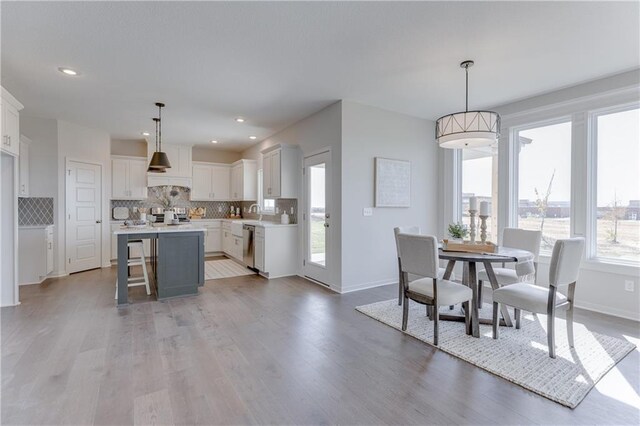 dining room featuring light wood-type flooring, recessed lighting, and baseboards