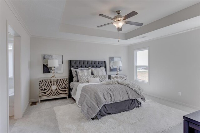 carpeted bedroom featuring ceiling fan, visible vents, crown molding, a raised ceiling, and baseboards