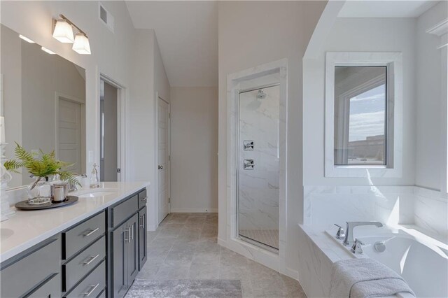 bathroom featuring a sink, double vanity, a shower stall, visible vents, and a garden tub