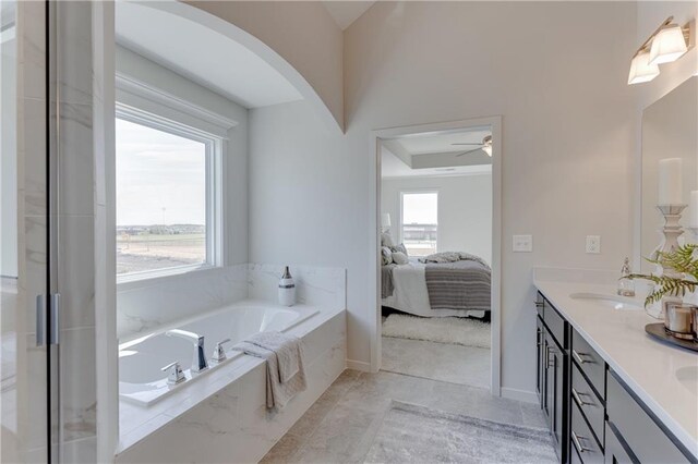 ensuite bathroom with ceiling fan, a sink, double vanity, ensuite bathroom, and a garden tub