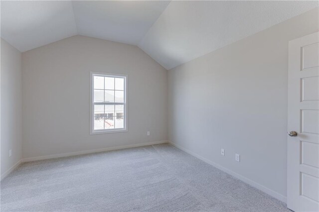 additional living space with baseboards, light carpet, and lofted ceiling