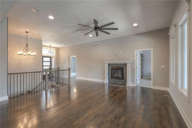 3525 S Woodland Ct, Independence, MO 64052 - unfurnished living room with visible vents, wood finished floors, baseboards, recessed lighting, and ceiling fan with notable chandelier