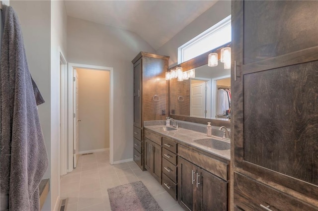 3525 S Woodland Ct, Independence, MO 64052 - bathroom with double vanity, a walk in closet, vaulted ceiling, and a sink