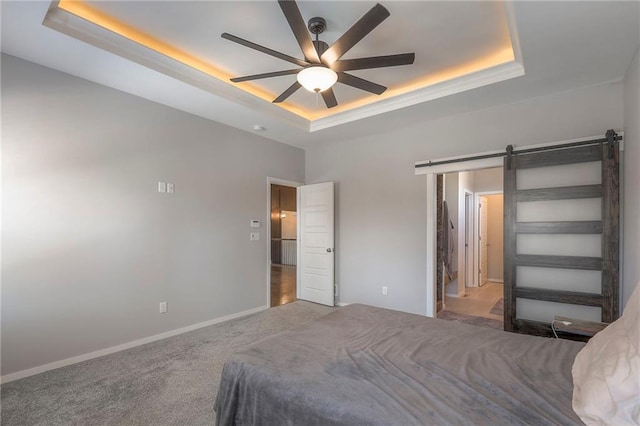 3525 S Woodland Ct, Independence, MO 64052 - bedroom with carpet flooring, baseboards, a barn door, a tray ceiling, and a ceiling fan