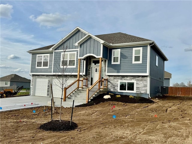 15610 Sheridan Ct, Basehor, KS 66007 - split foyer home with an attached garage, central AC, concrete driveway, and board and batten siding