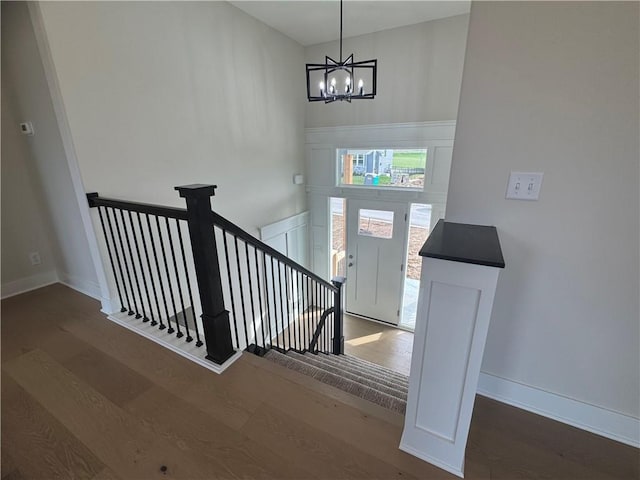 15610 Sheridan Ct, Basehor, KS 66007 - stairs with wood finished floors, a chandelier, and baseboards