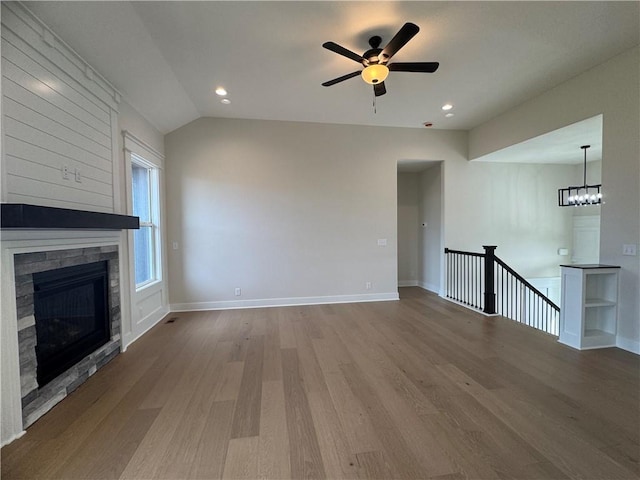 15610 Sheridan Ct, Basehor, KS 66007 - unfurnished living room featuring wood finished floors, ceiling fan, a stone fireplace, lofted ceiling, and recessed lighting