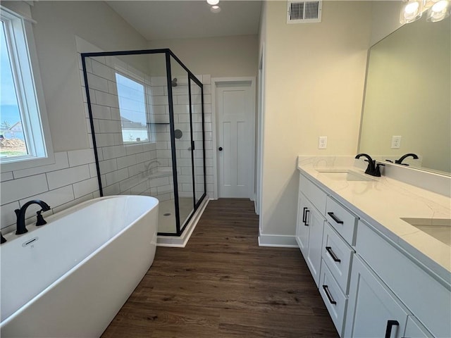 15610 Sheridan Ct, Basehor, KS 66007 - full bathroom featuring double vanity, a freestanding tub, wood finished floors, and a stall shower