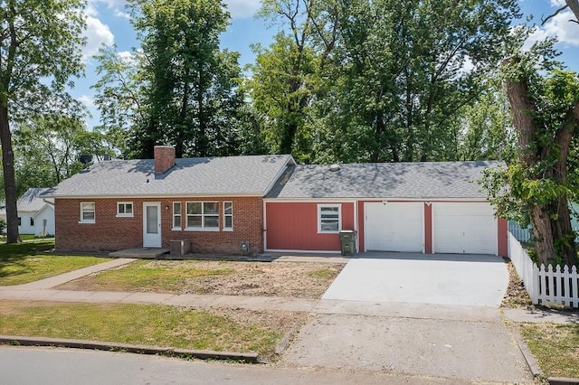 1001 Kickapoo St, Leavenworth, KS 66048 - single story home featuring a garage, concrete driveway, brick siding, a chimney, and a shingled roof