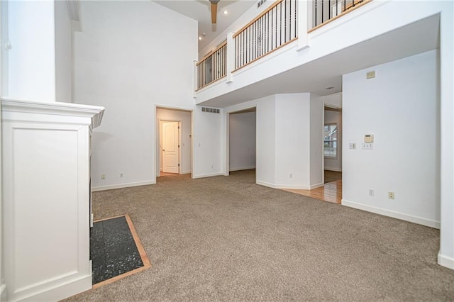 2500 Gabrianna Ct, Columbia, MO 65203 - unfurnished living room featuring carpet flooring, ceiling fan, baseboards, a towering ceiling, and visible vents