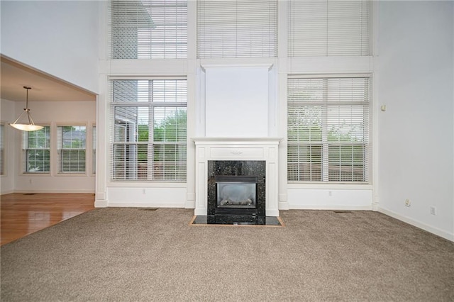 2500 Gabrianna Ct, Columbia, MO 65203 - unfurnished living room with carpet floors, baseboards, a high ceiling, and a premium fireplace