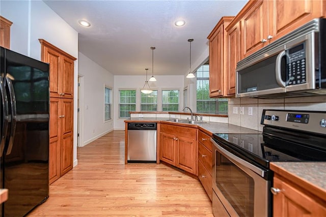 2500 Gabrianna Ct, Columbia, MO 65203 - kitchen featuring brown cabinetry, a sink, a peninsula, and stainless steel appliances