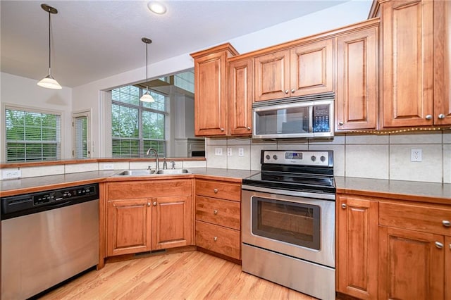 2500 Gabrianna Ct, Columbia, MO 65203 - kitchen featuring a sink, light wood-style flooring, appliances with stainless steel finishes, and brown cabinets