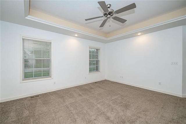 2500 Gabrianna Ct, Columbia, MO 65203 - carpeted empty room featuring visible vents, baseboards, ceiling fan, and a tray ceiling