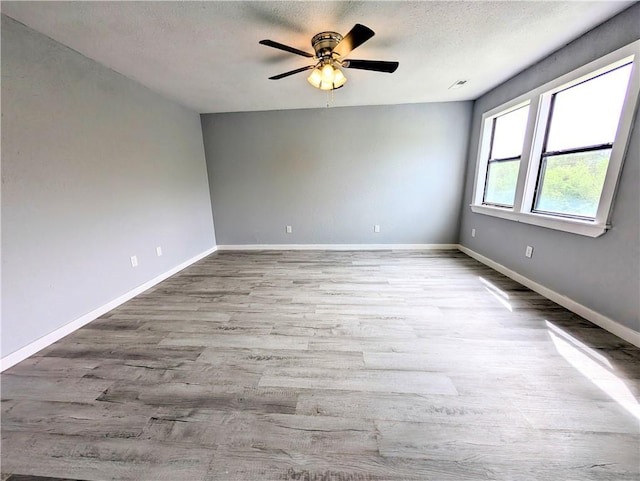 597 SE 110th St, Warrensburg, MO 64093 - unfurnished room with a textured ceiling, a ceiling fan, baseboards, wood finished floors, and visible vents