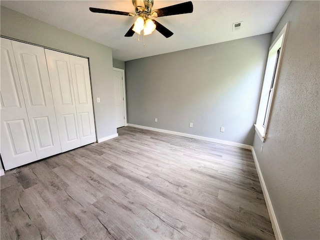 597 SE 110th St, Warrensburg, MO 64093 - unfurnished bedroom with a ceiling fan, baseboards, wood finished floors, visible vents, and a closet