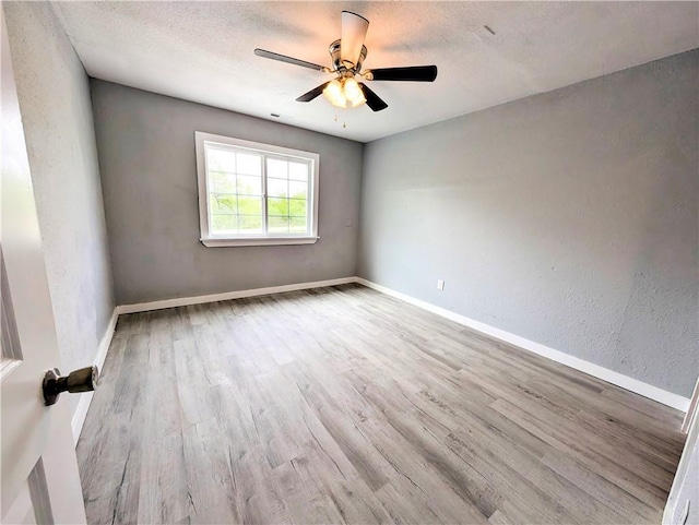 597 SE 110th St, Warrensburg, MO 64093 - unfurnished room featuring a ceiling fan, baseboards, wood finished floors, and a textured ceiling