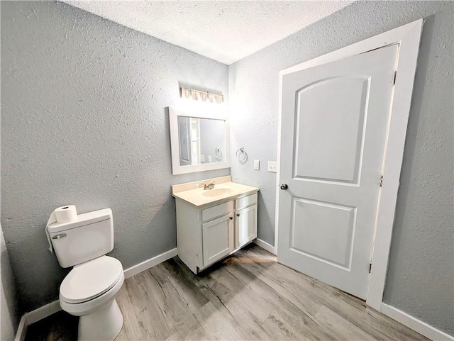 597 SE 110th St, Warrensburg, MO 64093 - bathroom featuring vanity, a textured wall, wood finished floors, toilet, and baseboards
