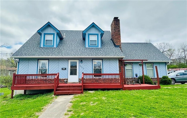 rear view of house with a lawn, a porch, a chimney, and a shingled roof
